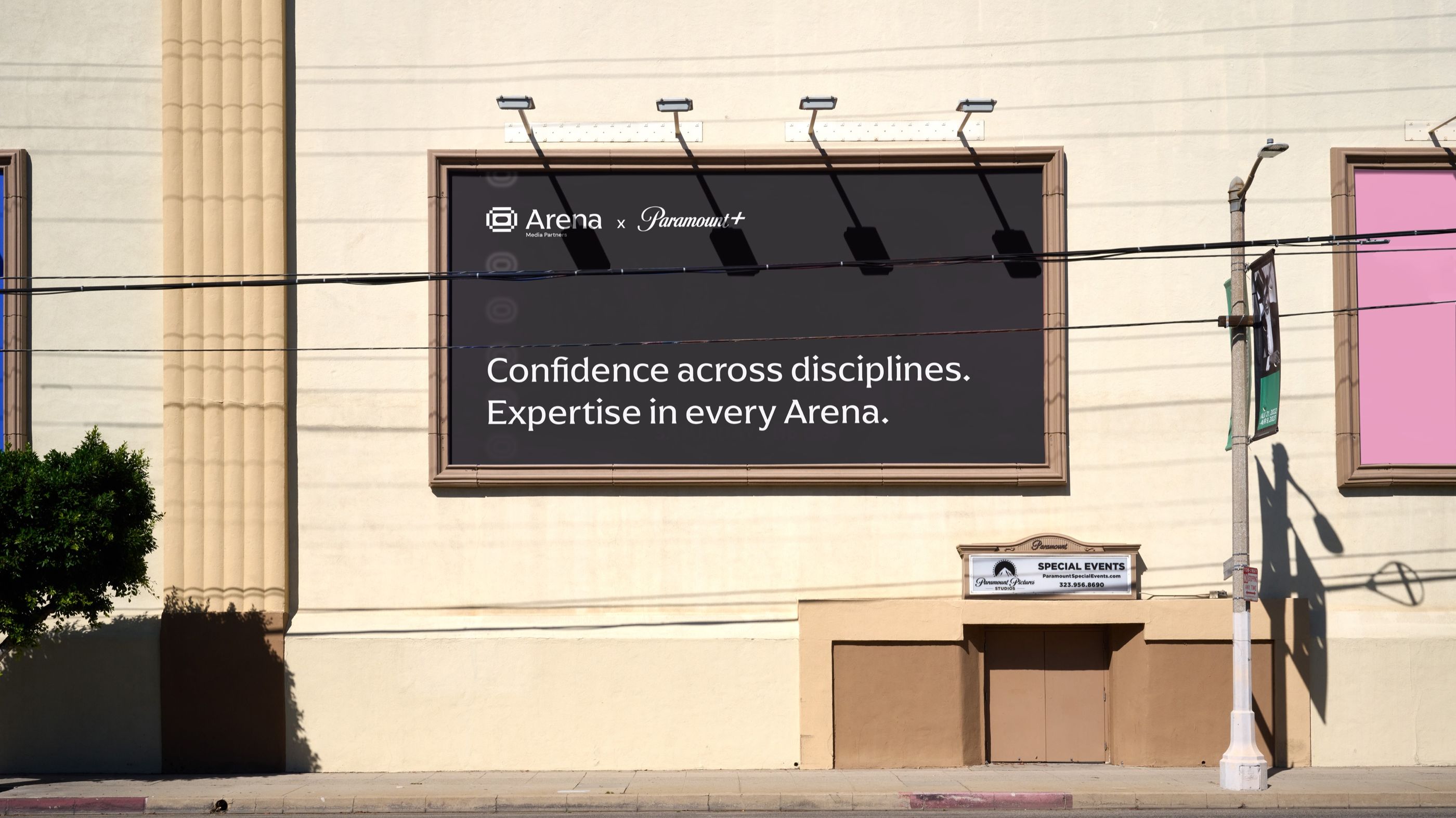 A billboard on a building reading “Confidence across disciplines. Expertise in every Arena.”