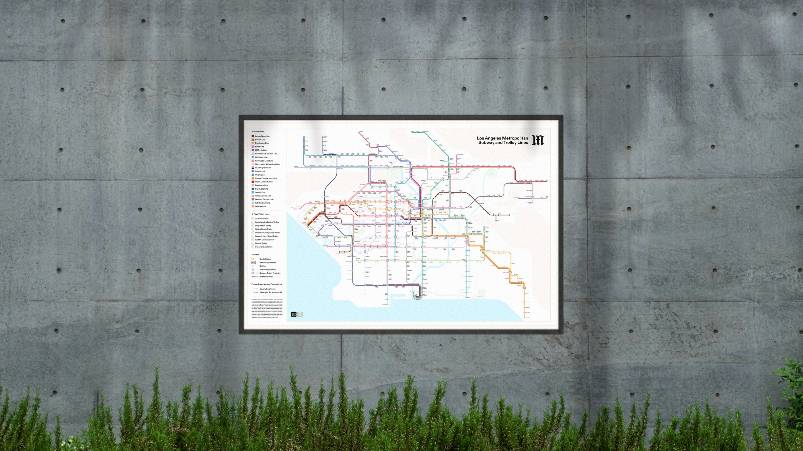 The Los Angeles Metropolitan system map, framed on a concrete wall above a strip of grass.