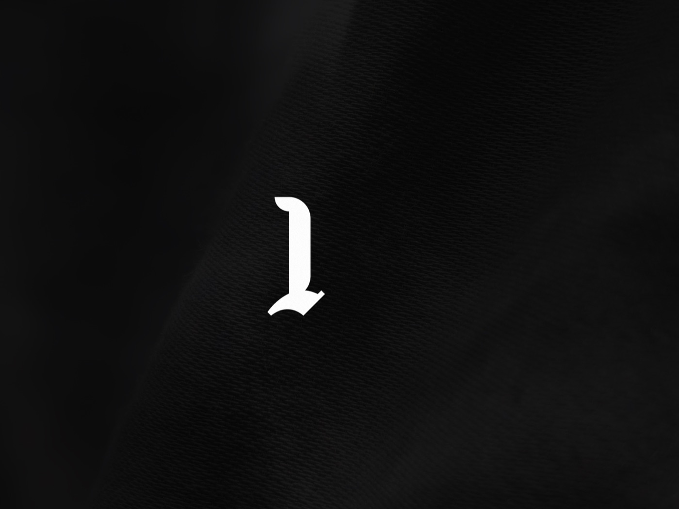 The blackletter M mark being assembled from an L and an A, then shown on staff identity cards, 2 of 7.