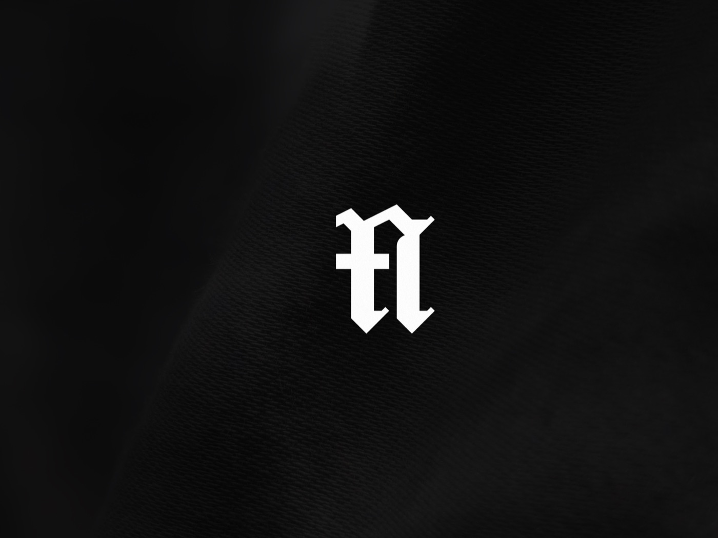 The blackletter M mark being assembled from an L and an A, then shown on staff identity cards, 3 of 7.