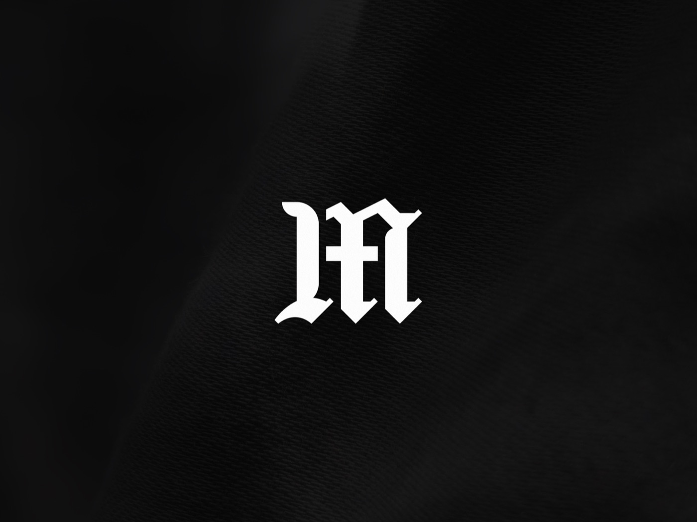 The blackletter M mark being assembled from an L and an A, then shown on staff identity cards, 4 of 7.